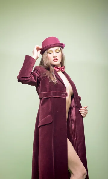 Sexy pretty girl in long coat wearing bowler hat and bow tie — ストック写真