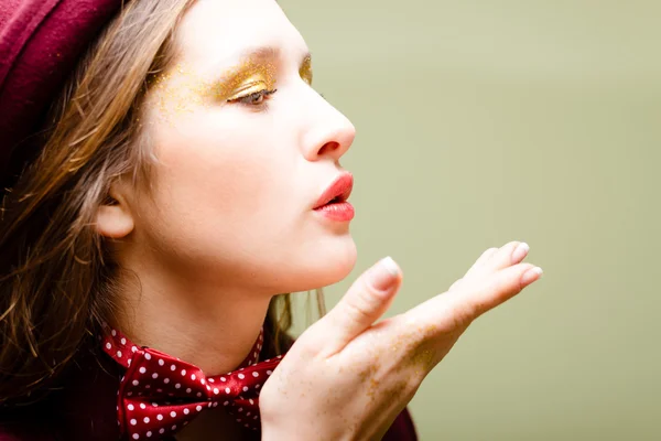 Air kiss closeup of girl in dotted bow tie on light green background — Stock Photo, Image