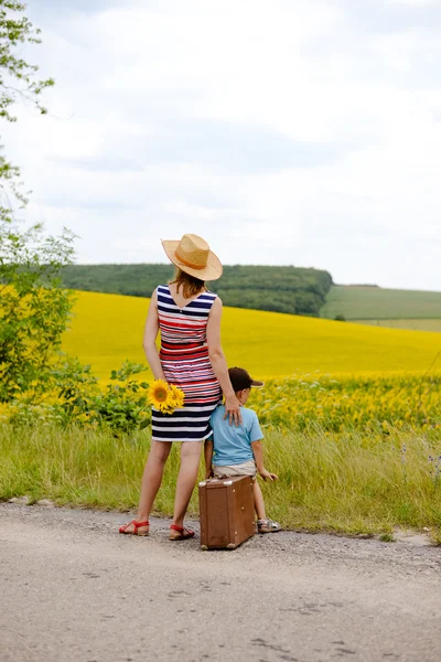 Backview of woman and boy on roadside near summer field — Stock Photo, Image