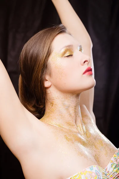 Menina com maquiagem dourada tonificada e pó dourado no pescoço — Fotografia de Stock