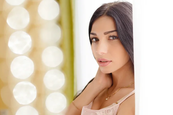 Portrait of brunette girl on golden toned party lights backround — ストック写真