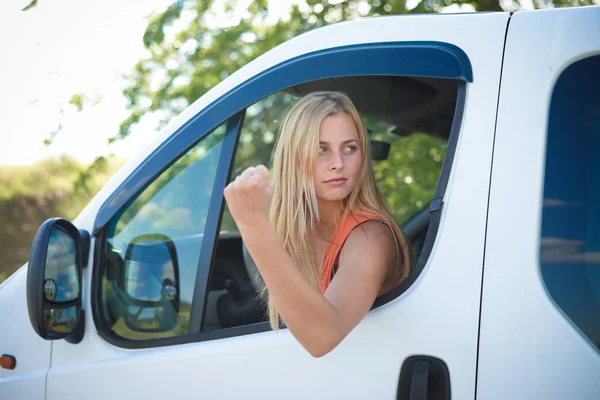 Retrato de chica rubia enojada en coche blanco mostrando puño en el borde de la carretera — Foto de Stock