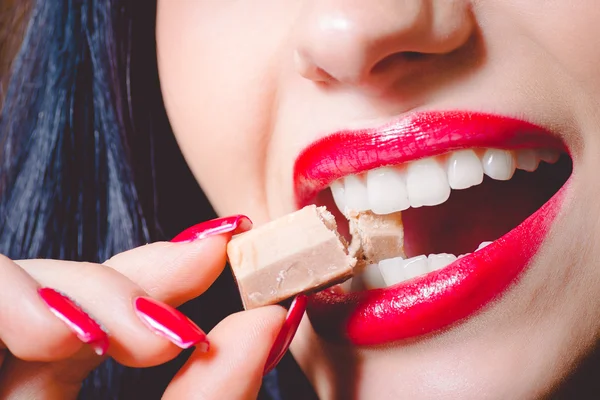 Closeup of brunette womans mouth biting big milk chocolate sweet — Stok fotoğraf