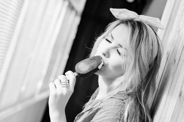 Immagine di bella giovane signora bionda sexy con gli occhi chiusi nel piacere di mangiare gelato. Immagine in bianco e nero — Foto Stock