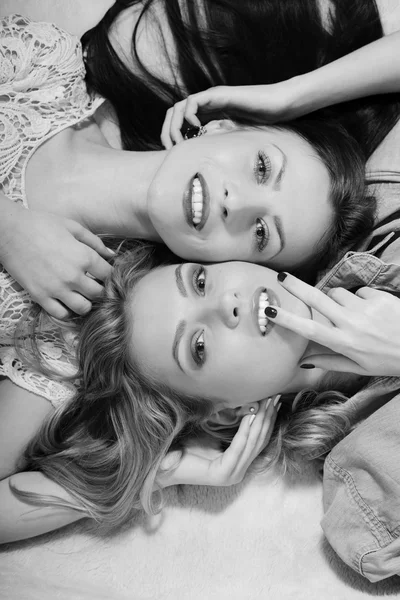 Дві гламурні сексуальні подружки лежать в ліжку разом голову до голови . — стокове фото