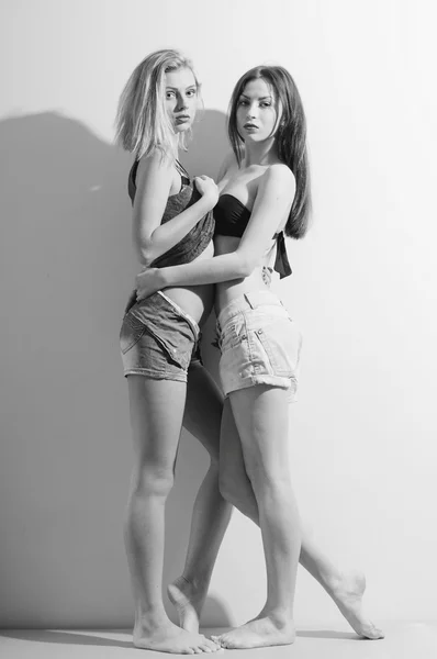 Two fashion sexy romantic beautiful girls in jeans shorts having fun and good time hugging each other — Zdjęcie stockowe