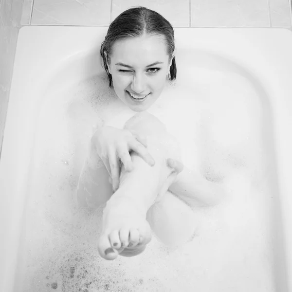 Retrato de una hermosa joven divirtiéndose feliz sonriendo y disfrutando apuntando a la cámara con la pierna —  Fotos de Stock