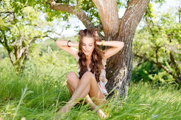 Картина радісної гламурної молодої красивої леді, що сидить на траві — стокове фото