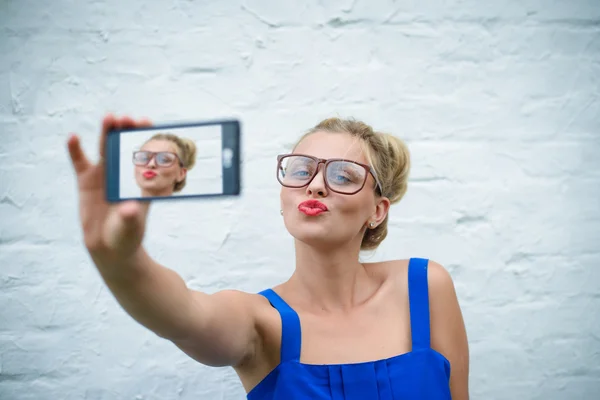 Pretty girl in glasses sending air kiss and making selfie — Stockfoto