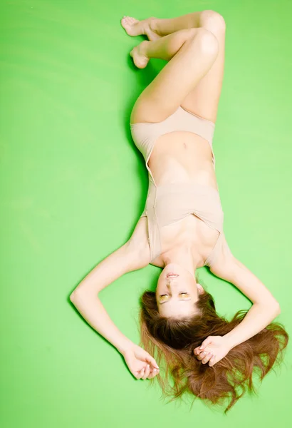 Upside down view of pretty woman in beige jumpsuit lying — Stock fotografie