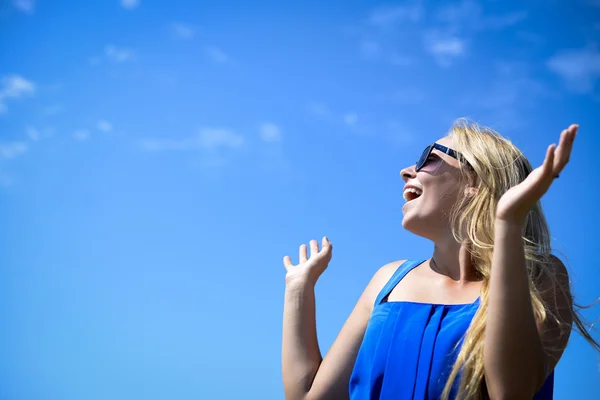 Happy girl in black sunglasses on bright blue sky background — Stok fotoğraf