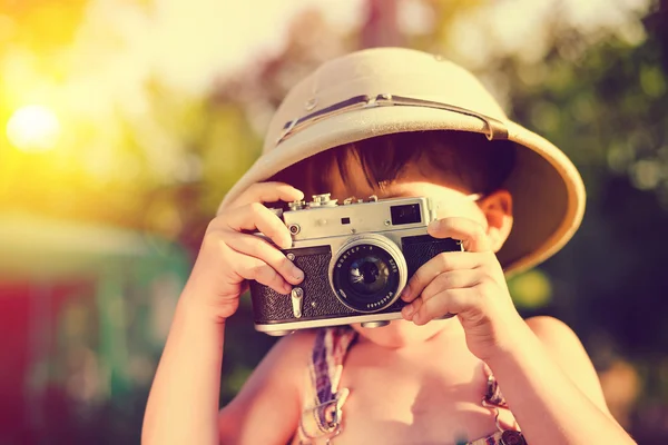 Küçük çocuk ilik miğfer vintage fotoğraf makinesi ile fotoğraf yapma — Stok fotoğraf