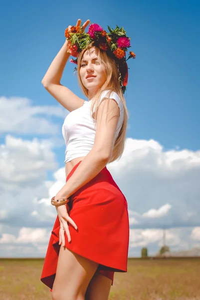 Stunning woman in bright flower wreath standing on wheat field — 图库照片