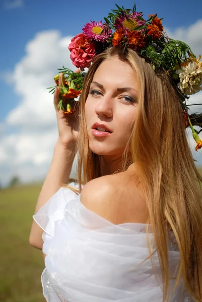 Girl in flower wreath with naked shoulder on countryside background — 图库照片