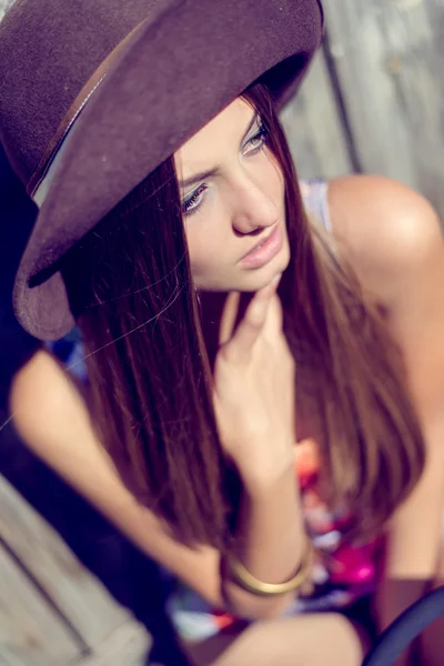 Молодая очаровательная леди в бледно-фиолетовой шляпе смотрит вдаль — стоковое фото