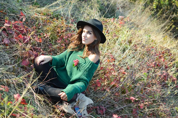 Mujer bonita en sombrero negro sonriendo en el soleado fondo de otoño — Foto de Stock