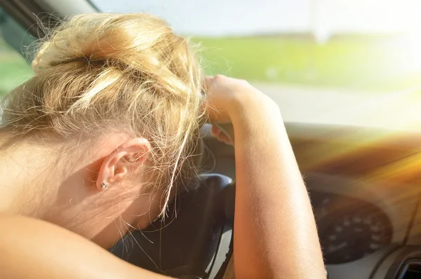 Closeup picture of young pretty lady waiting in car leaning on wheel on summer day outdoors background with eyes closed — Stock Photo, Image