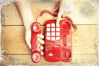 Human hands holding phone handle and dialing, closeup picture