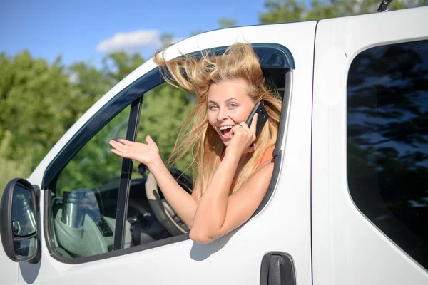 Mujer rubia joven emocionado y hablando de teléfono en coche blanco — Foto de Stock