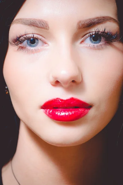 Schönes brünettes Frauengesicht mit roten Lippen und blauen Augen — Stockfoto