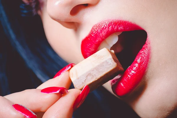 Closeup of brunette woman who tasting big milk chocolate sweet — Stok Foto