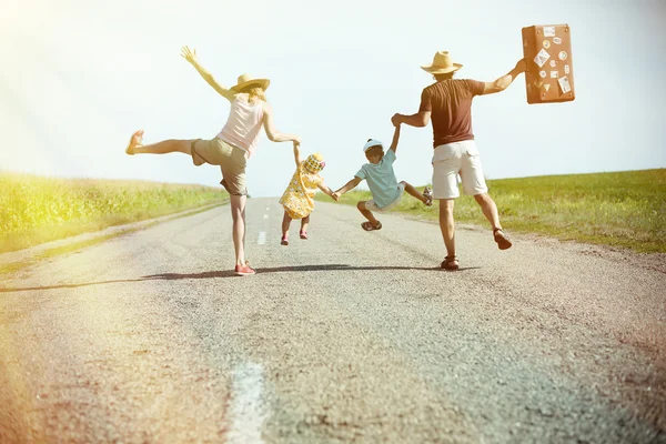 Familia feliz tomándose de las manos en el soleado camino rural — Foto de Stock