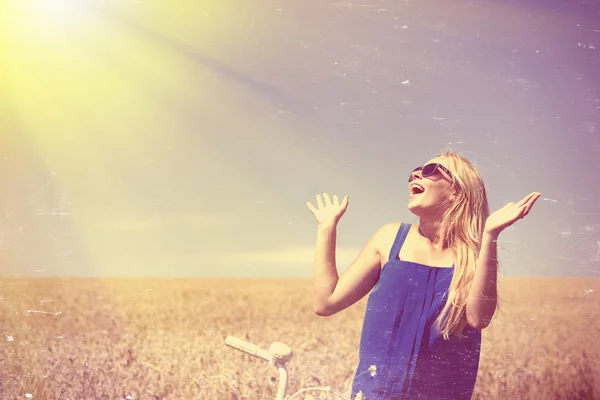 Loira menina feliz usando óculos de sol animado com luz solar brilhante no campo — Fotografia de Stock