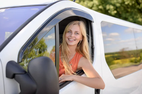 Joven mujer rubia bonita conduciendo coche blanco y feliz sonriendo — Foto de Stock