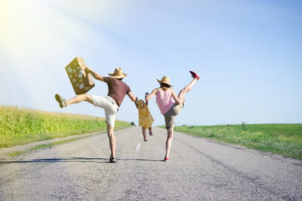 Happy family jumping and having fun on road in summer — Stock Photo, Image