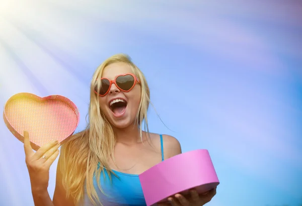 Happy girl excited opening heart shaped giftbox on sky background — 스톡 사진