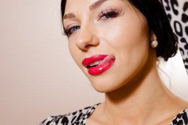 Closeup of sexy beautiful girl in animal print top licking lips