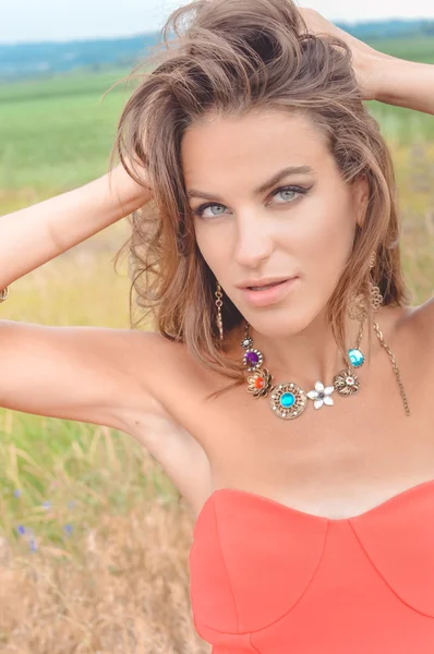 Sexy girl wearing coral top and fancy necklace in countryside — Stock Fotó