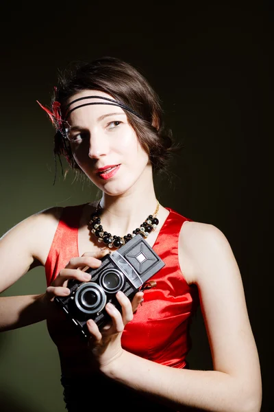 Charming girl in retro red dress with vintage photo camera — Stock fotografie