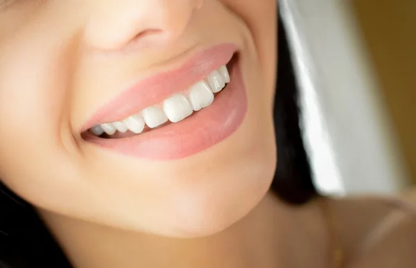 Beautiful happy smile of brunette girl in blurred indoor background