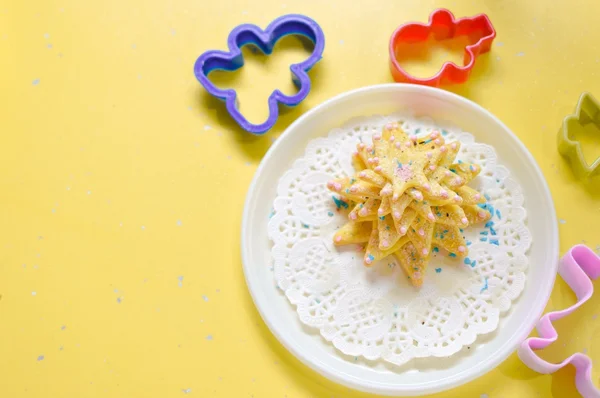 Gambar kue buatan tangan atau kue di piring putih dengan cetakan di ruang fotokopi meja kuning — Stok Foto