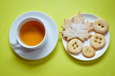 Image close up of cookies and cup of tea on green background