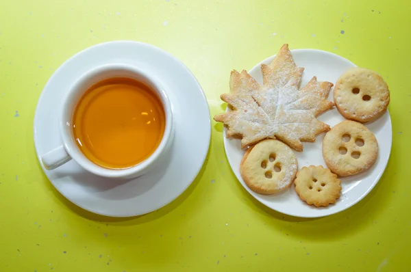 Close up on cup of green tea and homemade festive cookies over bright green copy space — Stock Photo, Image