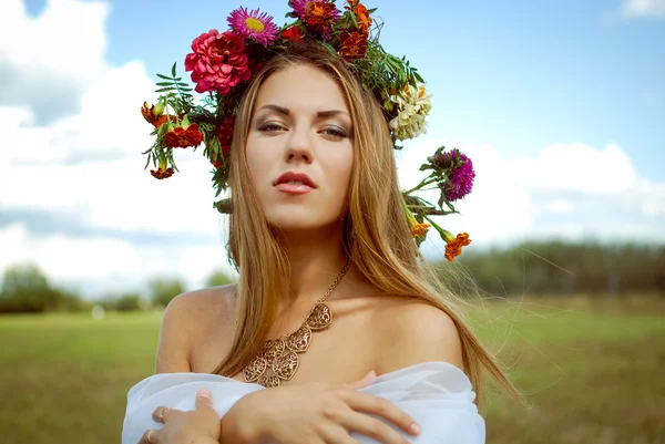 Pretty girl in flower wreath with naked shoulders in countryside — Stock Photo, Image