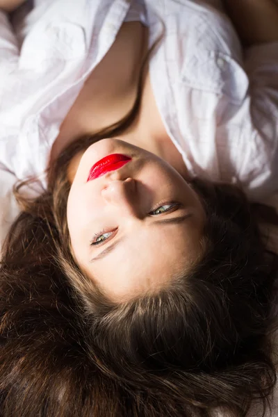 Upside down image of young woman with red lips laying — 图库照片