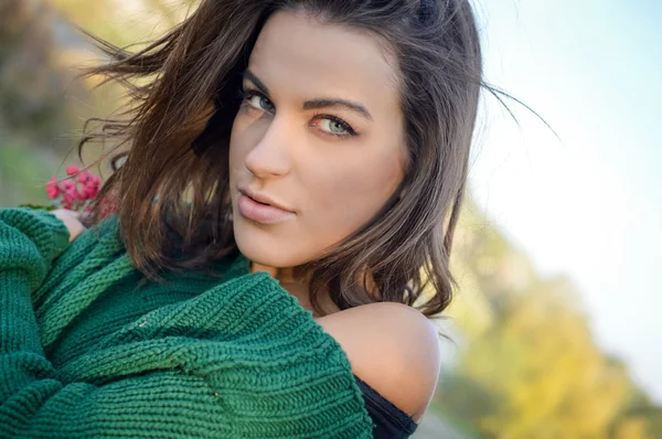 Beautiful hiding girl with tangled hair wearing green sweater in countryside — ストック写真