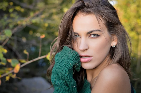 Portrait of beautiful hiding girl with tangled hair wearing green sweater in countryside — Stockfoto