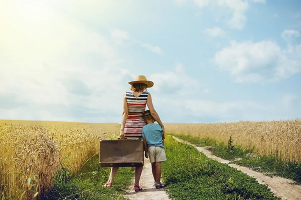 Woman and little boy standing in middle of country road — Stock Photo, Image