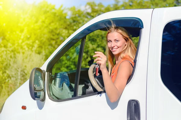 Imagen de chica bonita increíble sosteniendo la llave del coche y mirando desde la ventana del coche . — Foto de Stock