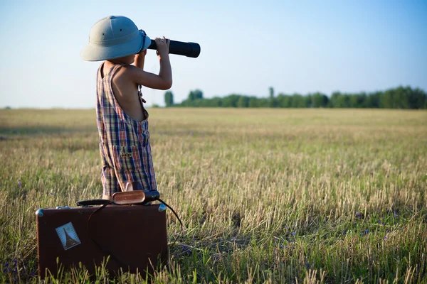 Little boy looking in the distance in the field using military binocular — Zdjęcie stockowe