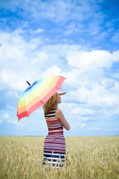 Imagem da menina loira olhando para a distância sob guarda-chuva no campo de trigo sobre o céu azul ao ar livre fundo — Fotografia de Stock