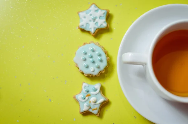 Biscotti allo zenzero fatti a mano e tazza di tè su sfondo verde — Foto Stock