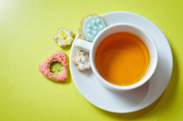 Närbild av ingefära cookies och kopp te på ljusgrön bakgrund — Stockfoto