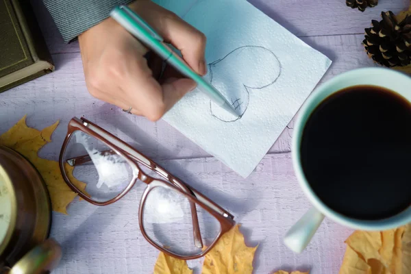 Hand drawing heart sketch on napkin with autumn decor beside — 스톡 사진