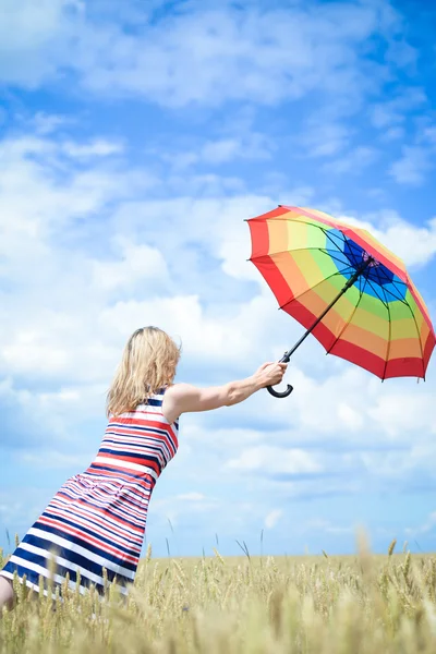 Romântico fêmea voando com guarda-chuva no campo de trigo no céu azul ensolarado ao ar livre fundo — Fotografia de Stock