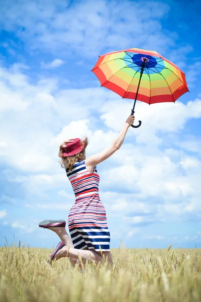 Salto feliz sonhando mulher com guarda-chuva no campo de trigo — Fotografia de Stock